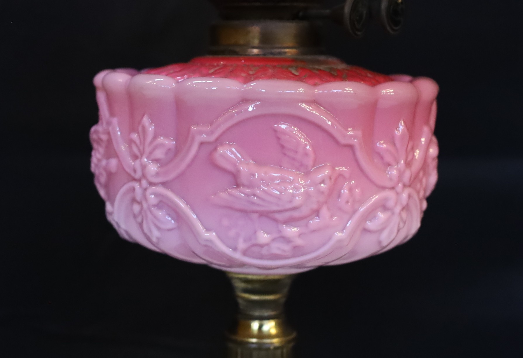 A late Victorian brass and pink opaque glass oil lamp with tinted frosted shade, height overall 56cm